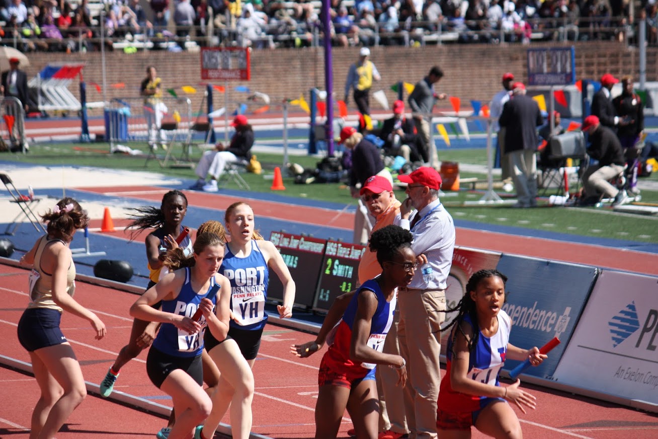 Senior captain Megan Mazzini passes the baton to senior captain Lucy Hurt during the 4x400 meter relays at the 2018 Penn Relays.