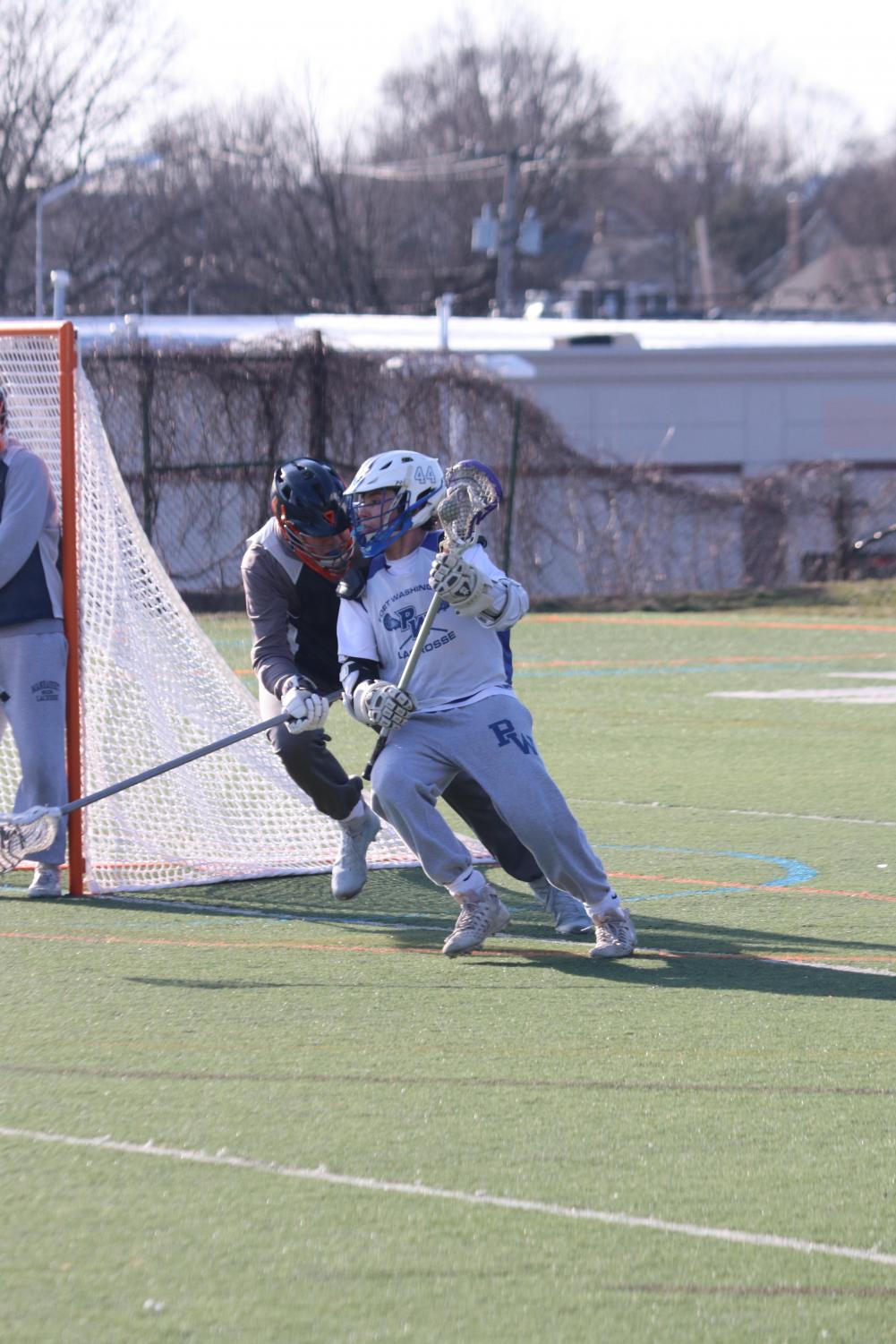 Senior John Athanasian looks to beat a defender around the net during a home game on April 12 against Kellenberg. The Vikings went on to lose the match by a score of 12-16.