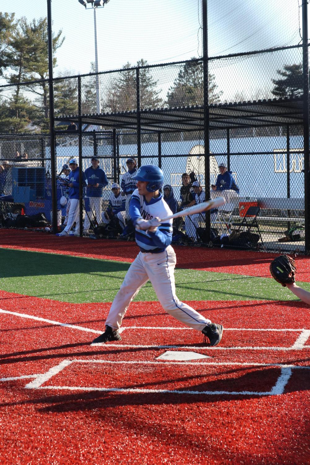 Senior Jack Stopler hacks at a pitch during a home game against Hicksville on March 29. The team went on to win the game 10-5.