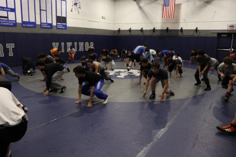 The varsity wrestling team prepares for its season during a workout in the wrestling gym.
