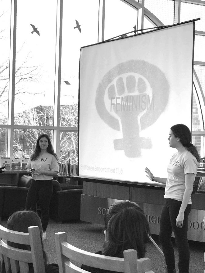 Seniors+Annie+Bandler+and+Hannah+Hirsch+conduct+a+presentation+meant+to+spread+awareness+to+students+in+Schreiber%27s+library.